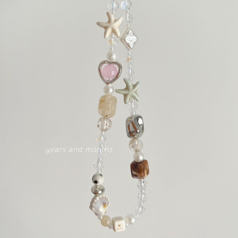 Crystal beaded phone strap with rutilated quartz, starfish beads, pearls, and pink heart charm for beach-style accessories