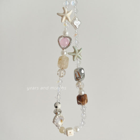 Crystal beaded phone strap with rutilated quartz, starfish beads, pearls, and pink heart charm for beach-style accessories